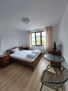 科普里夫什迪察Kъща за гости Демария的卧室配有1张床、1张桌子和1把椅子