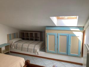 毕博纳的码头Parco Vacanze La Rosa dei Venti的一间卧室配有一张床和一个蓝色的橱柜