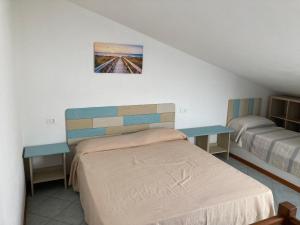 毕博纳的码头Parco Vacanze La Rosa dei Venti的一间卧室配有一张床和两张桌子