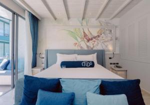 普吉镇Hotel Tide Phuket Beach front - SHA Plus的一间卧室配有一张带蓝色枕头的大床