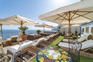 波西塔诺Villa Nina的一个带椅子和遮阳伞的庭院和大海