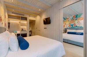 普吉镇Hotel Tide Phuket Beach Front的一间酒店客房,配有一张床和一台电视