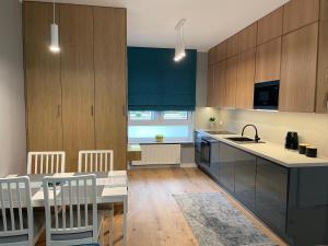 马佐夫舍地区新庄园Caroline Jacuzzi Apartments的厨房配有木制橱柜和带水槽的桌子。
