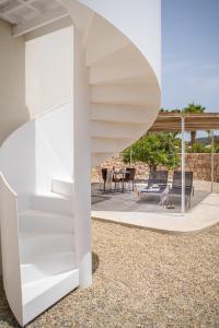 伊维萨镇Can Jaume Private Villas by Ocean Drive的白色的房子,设有螺旋楼梯和庭院