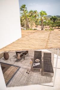 伊维萨镇Can Jaume Private Villas by Ocean Drive的庭院配有两把椅子、一张桌子和一张桌子以及椅子。