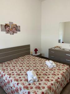 斯佩基亚Casa Salento的一间卧室配有带毛巾和梳妆台的床