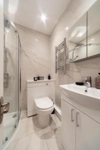 伦敦Kensington luxury flat with patio的白色的浴室设有卫生间和水槽。