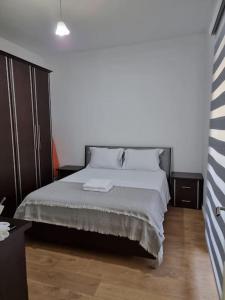 地拉那Zyli Apts, BY Bunker Art 2 Museum, Tirana的一间卧室配有带白色床单和枕头的床。