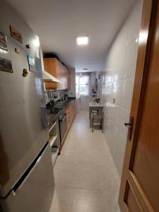 安波拉Estupendo piso en L'AMPOLLA的厨房配有不锈钢冰箱和桌子