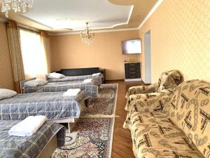 博孔巴耶沃Guest house Ayperi的客房设有两张床、一张沙发和一台电视。