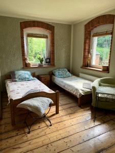 宇格维斯Przytulne Siedlisko的一间卧室配有两张床、椅子和两个窗户。