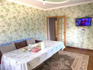 博孔巴耶沃Guest house Ayperi的客厅配有一张带白色桌布的桌子