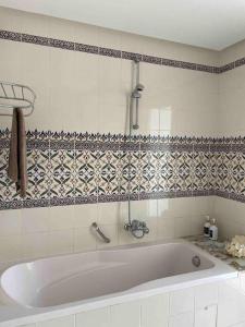 塔巴卡Villa avec piscine privée的瓷砖浴室设有白色浴缸。