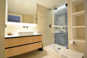 波伊奥RD Hotel Apartamento的一间带水槽和玻璃淋浴的浴室
