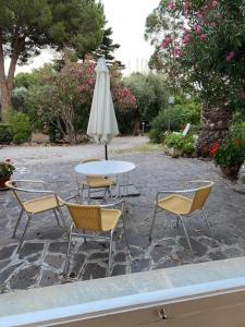里奥马里纳Isola d'Elba casa vacanze - Villa Portello - la casina bis - quarzo-pirite的桌椅、桌子和雨伞
