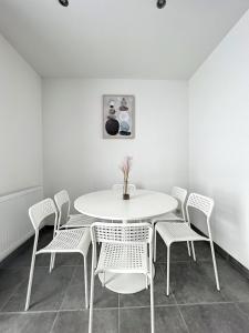 沙勒罗瓦Wauters 75 Bruxelles-charleroi-airport的白色的用餐室配有白色的桌椅