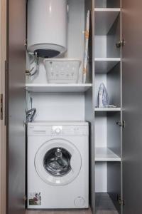 雅典Apartment in Keramikos, Athens的一个带架子的房间的洗衣机和烘干机