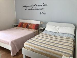 弗利Villa Viola的卧室配有两张床,墙上有一段名言