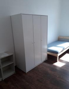 霍夫Monteurszimmer in Hof的一间设有白色橱柜和一张床的房间