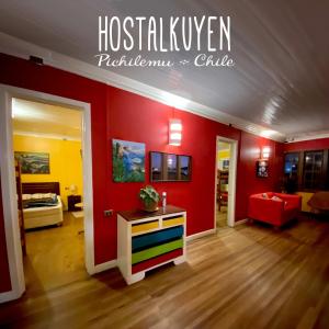 皮奇勒姆Hostal Kuyen的一间客厅,里面设有红色的墙壁和色彩缤纷的房间