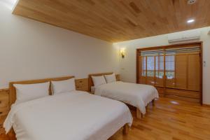 Yung-an-ts'un后山人家民宿A馆的配有2张床的客房设有木地板和窗户。