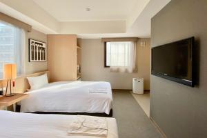 京都京都糸屋酒店的酒店客房设有两张床和一台平面电视。