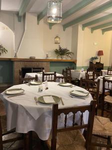 格拉茨莱马Hospederia Casa de las Piedras的用餐室配有带白色桌布的桌子