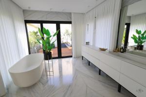 荷兹利亚Breathtaking Villa w Pool & Sauna Near the Beach by Sea N' Rent的浴室配有白色浴缸和大镜子