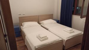 都拉斯Villa Eden 111, Perla Resort, Bay of Lalzi的小型客房配有2张单人床和蓝色窗帘