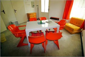 德兰斯克DDR Bungalow direkt am Strand auf Rügen的客厅配有桌子和红色椅子
