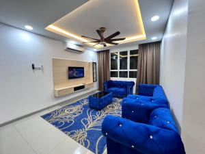 瓜拉丁加奴Qaisara Qais Homestay的客厅配有蓝色的沙发和电视