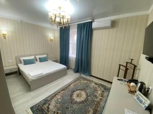 库斯塔奈Hotel Astam的一间卧室配有一张带蓝色枕头的床和地毯。