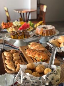 佩尼亚Pousada Casa Albatross的一张桌子,上面放着许多不同类型的面包和糕点