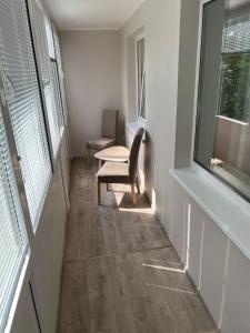 希奥利艾Vanilės home的走廊上设有椅子、桌子和窗户