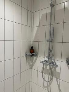 NiederalmCasa Móre BEIGE的白色瓷砖浴室内带软管的淋浴