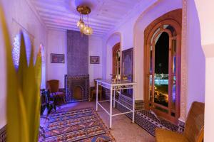 丹吉尔Riad Villa with Mediterranean Sea Views of Spain and Gibraltar的一间拥有紫色墙壁和一张桌子的房间