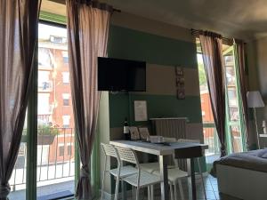 阿斯蒂Bon Bon del Corso con terrazzo e aria condizionata的客房设有桌椅和窗户。