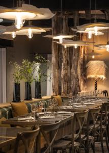 查姆布里陶德Cit'Hotel Le Relais du Boisniard的用餐室配有长桌子、椅子和灯