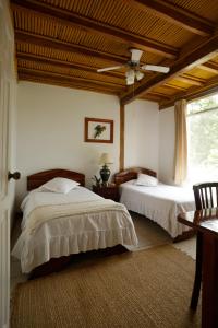 米萨华丽港Misahualli Amazon Lodge的一间卧室配有两张床和吊扇