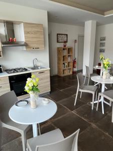 库特罗菲安诺Percebes Exclusive B&B的厨房配有2张桌子、白色椅子和柜台