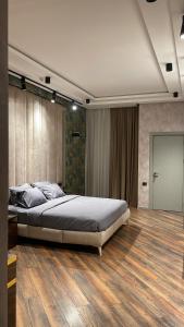 巴库Park Vurğun Residance Loft Designer的一间卧室设有一张大床,铺有木地板