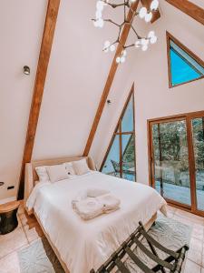 Tiny Pines A-Frame Cabin, Domes and Luxury Glamping Site的一间卧室配有带毛巾的床
