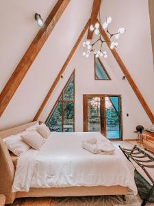 Tiny Pines A-Frame Cabin, Domes and Luxury Glamping Site的阁楼卧室配有白色床