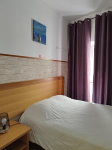 塔维拉瓜斯旅馆的一间卧室配有一张床、一张桌子和一个窗户。