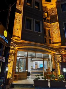 格克切达镇İmroz Adali's Butik Otel的一座带玻璃门的建筑,里面设有桌子