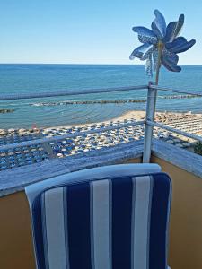 蒙特西尔瓦诺La Terrazza sul Mare的海滩前的蓝白椅子