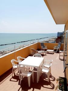 蒙特西尔瓦诺La Terrazza sul Mare的一个带桌椅和海滩的阳台