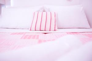斯普利特坦卡瑞瓦公寓酒店的白色的床,配有粉红色和白色条纹的枕头