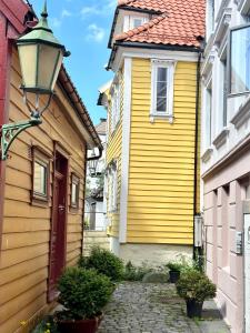 卑尔根Knøsesmauet Apartment的前面有路灯的黄色房子