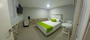 卡塔赫纳Hotel BM-17 Cerca Al Mar Con Aire Acondicionada y Wifi的一间小卧室,配有一张床和一张小桌子